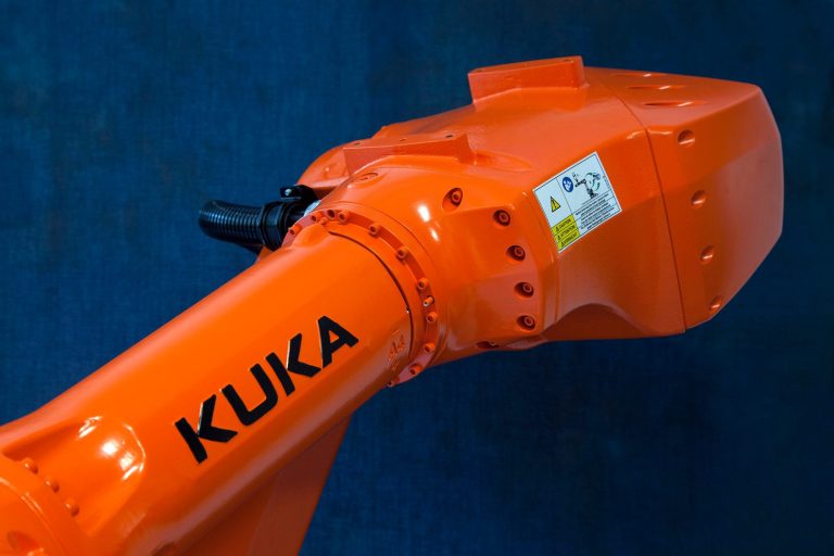 Der orange Roboterarm von dem Roboter ist glänzend und in verschiedenen Positionen einzurichten.