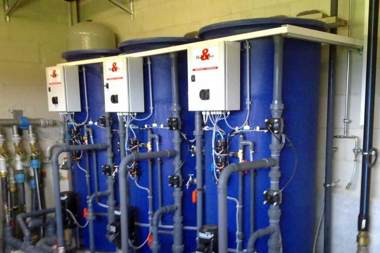 Drei nebeneinanderstehende Wasseraufbereitungsanlagen zur Enteisung von Wasser.